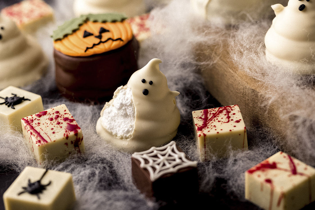 Ideia de mesa de doces para Halloween com pães de mel, fantasmas de marshmallow e biscoitos decorados com tema assustador